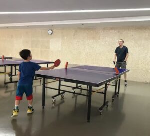 Teacher and kid playing ping pong