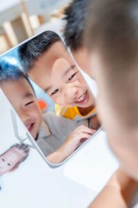 Students looking in mirror (learning through play)